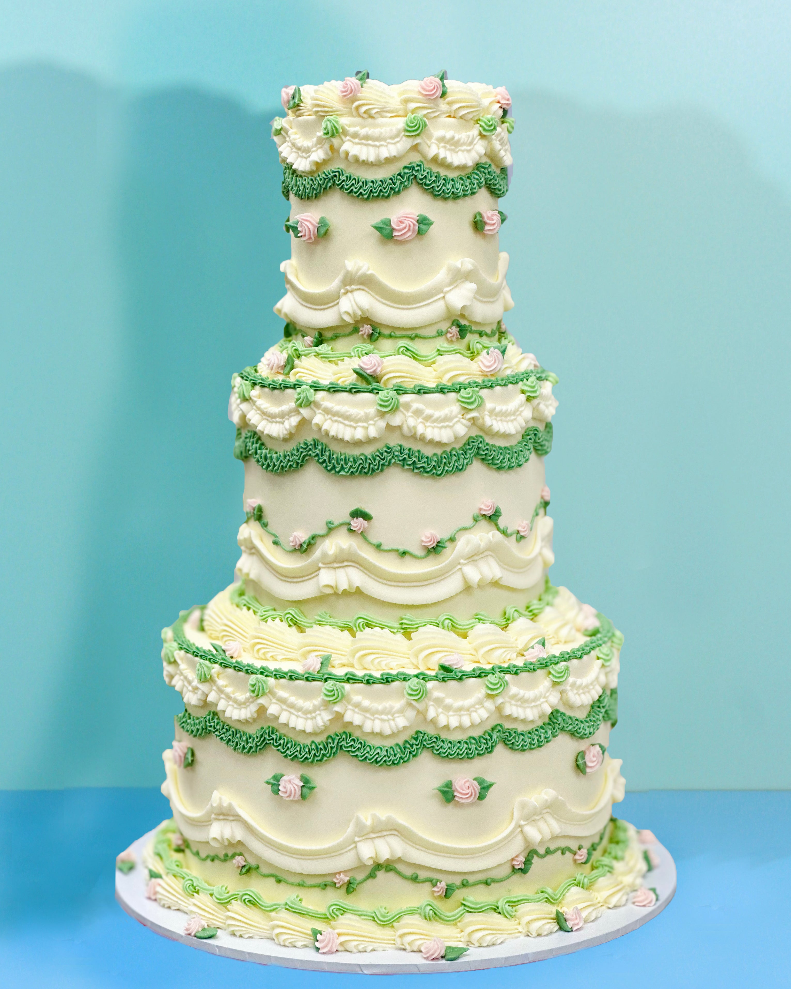 Three-tier botanical wedding cake with hand-piped floral detailing