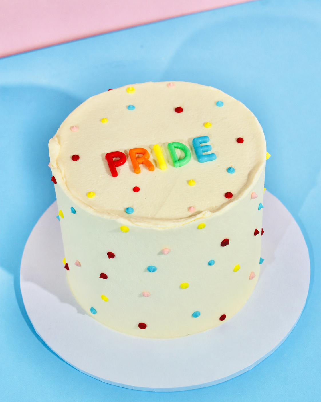 Polka dot Pride cake with colourful buttercream dots
