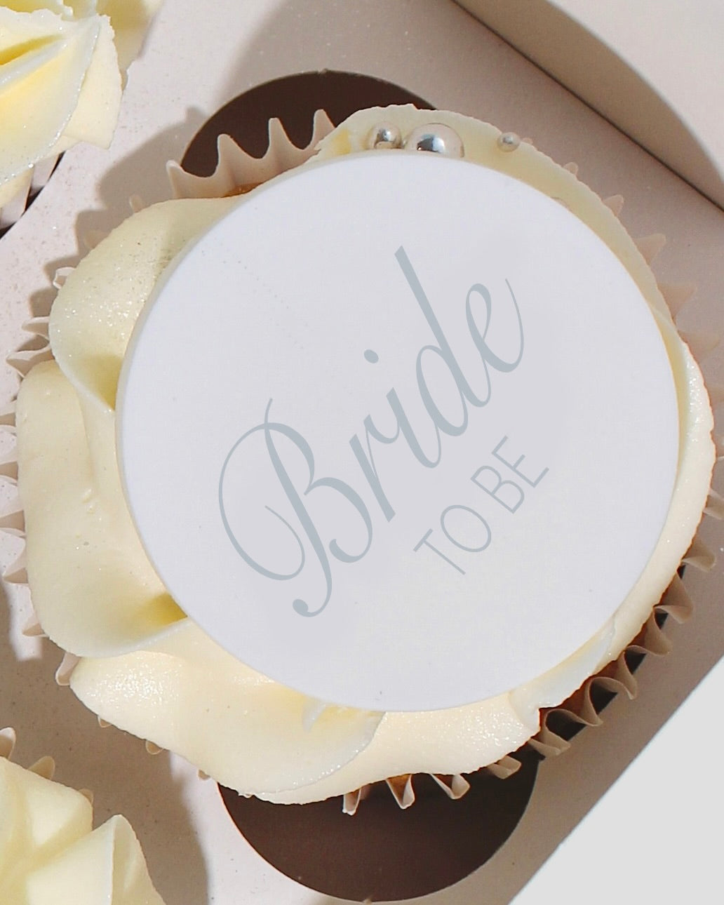 Bride-to-Be cupcake with ivory piped buttercream and edible topper.
