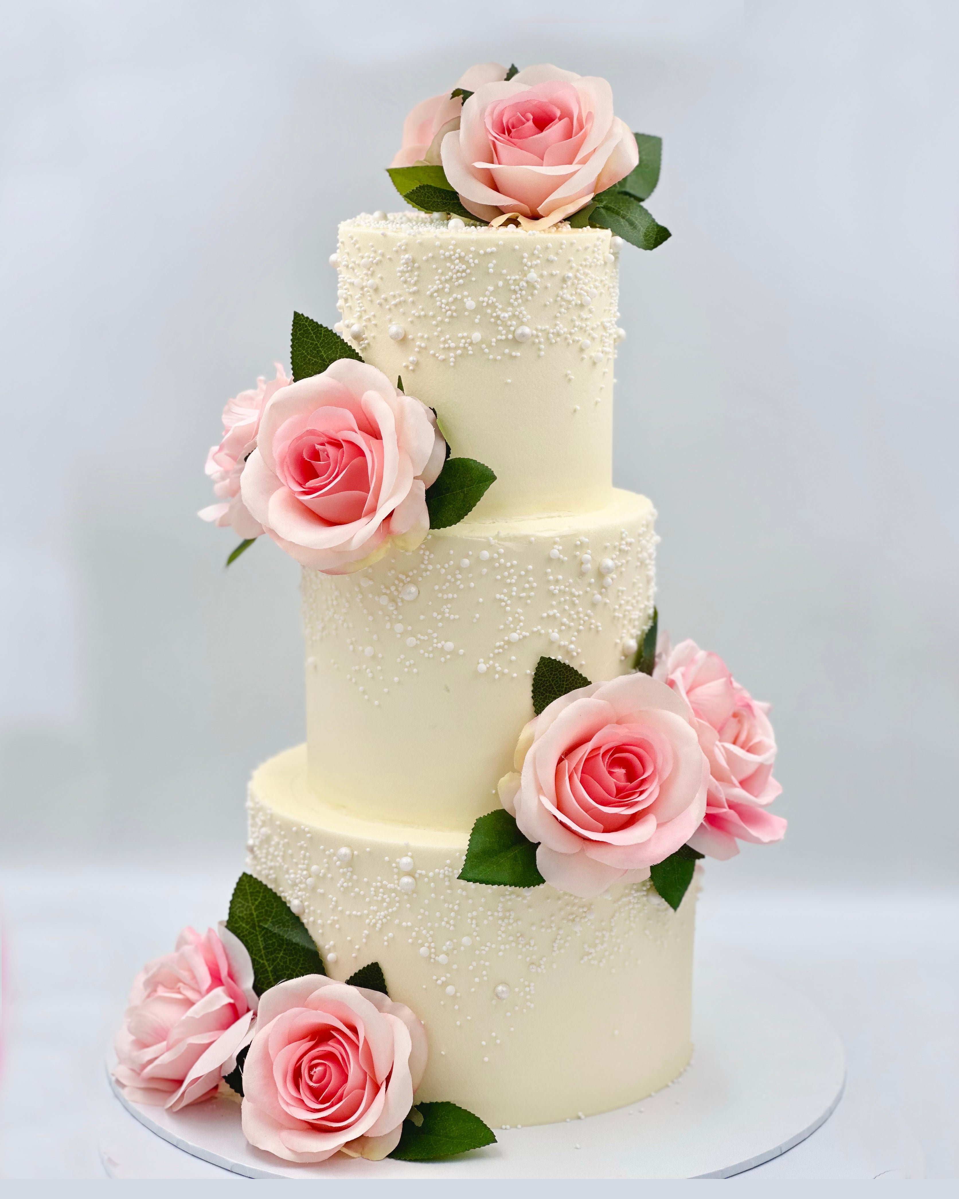 Ivory wedding cake with blush pink roses and pearl detailing