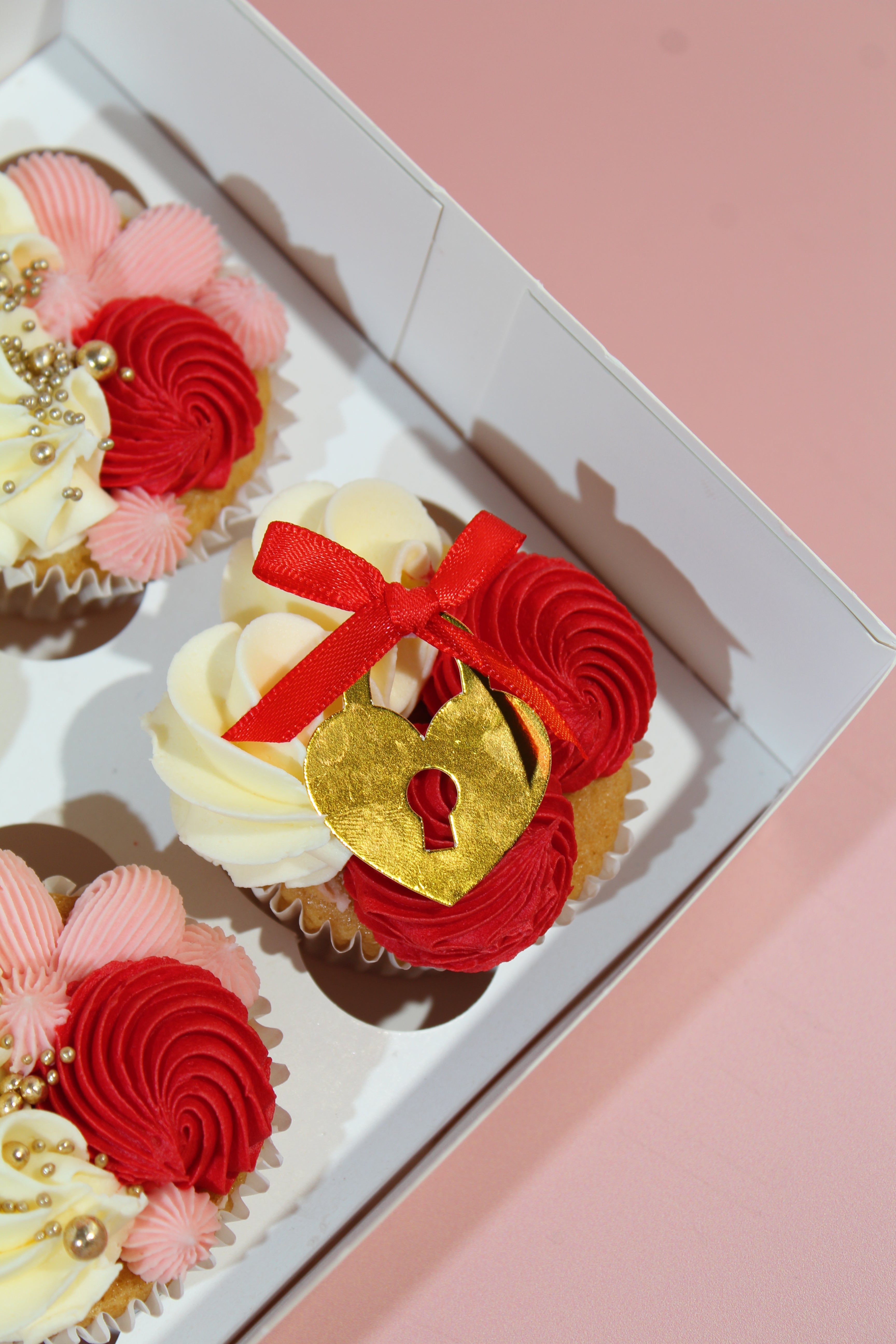 Heart locket cupcake with red buttercream, vanilla frosting and satin bow
