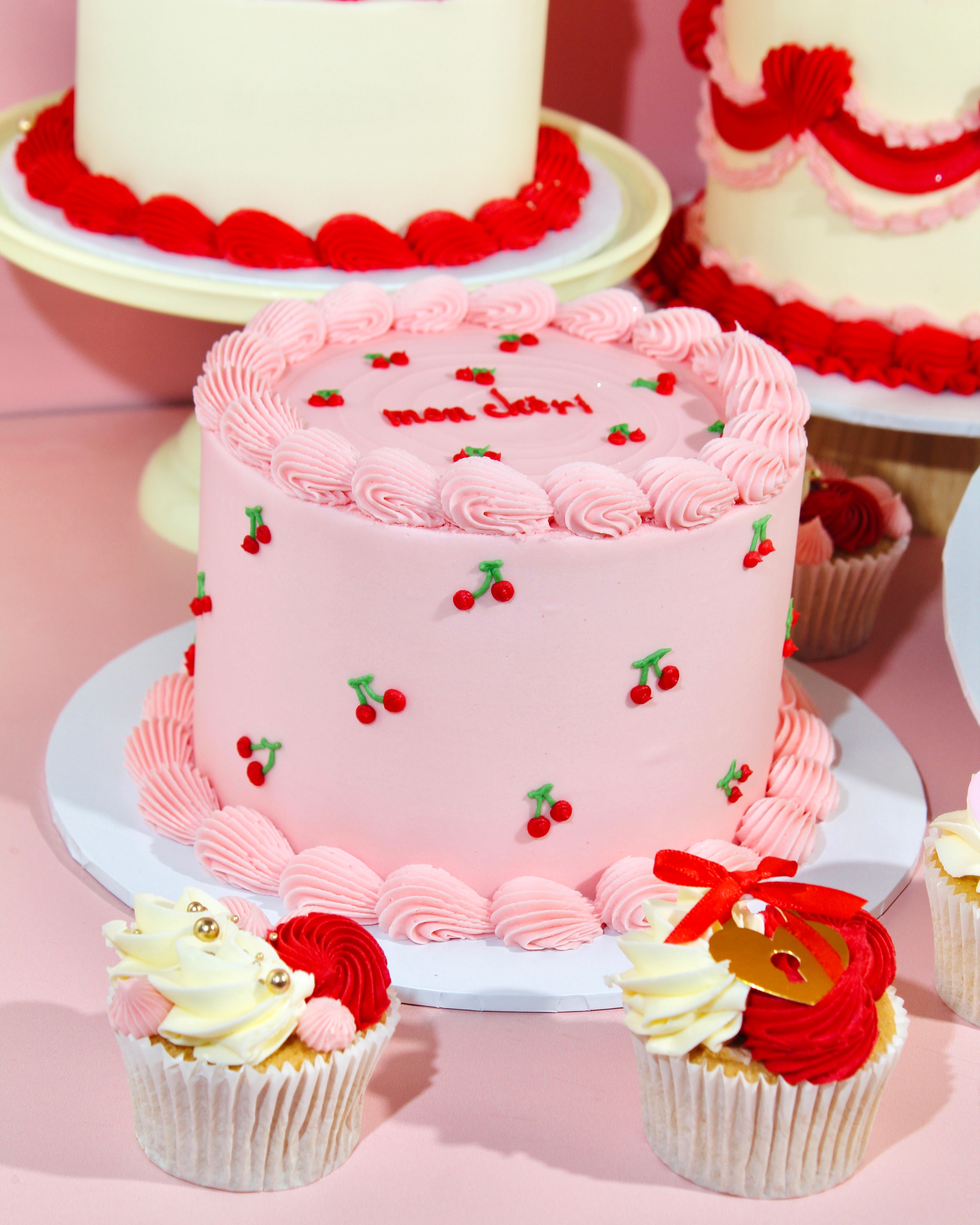 Romantic pink cherry cake with piped buttercream edges on display stand