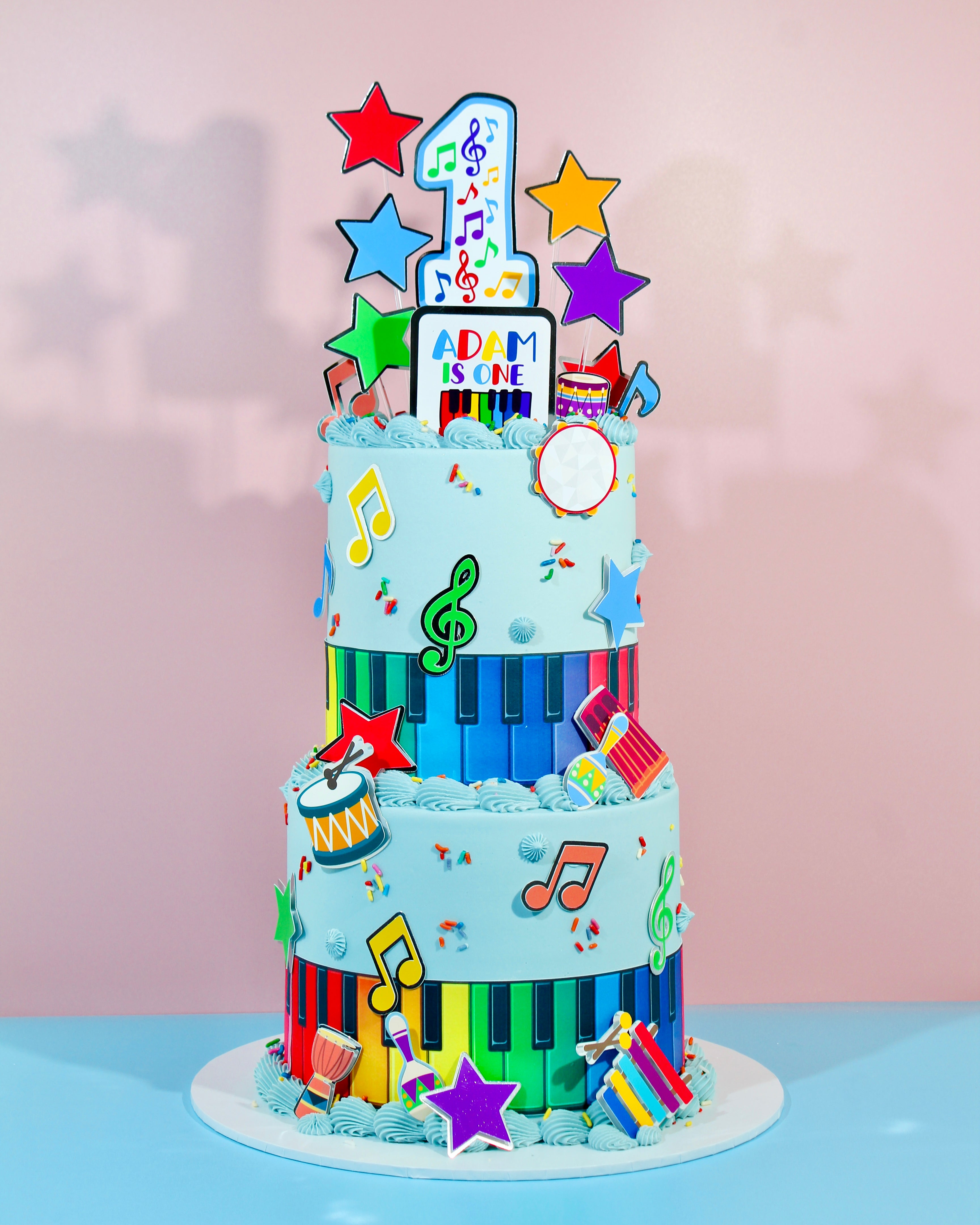 Colourful music-themed birthday cake with rainbow piano keys and star toppers