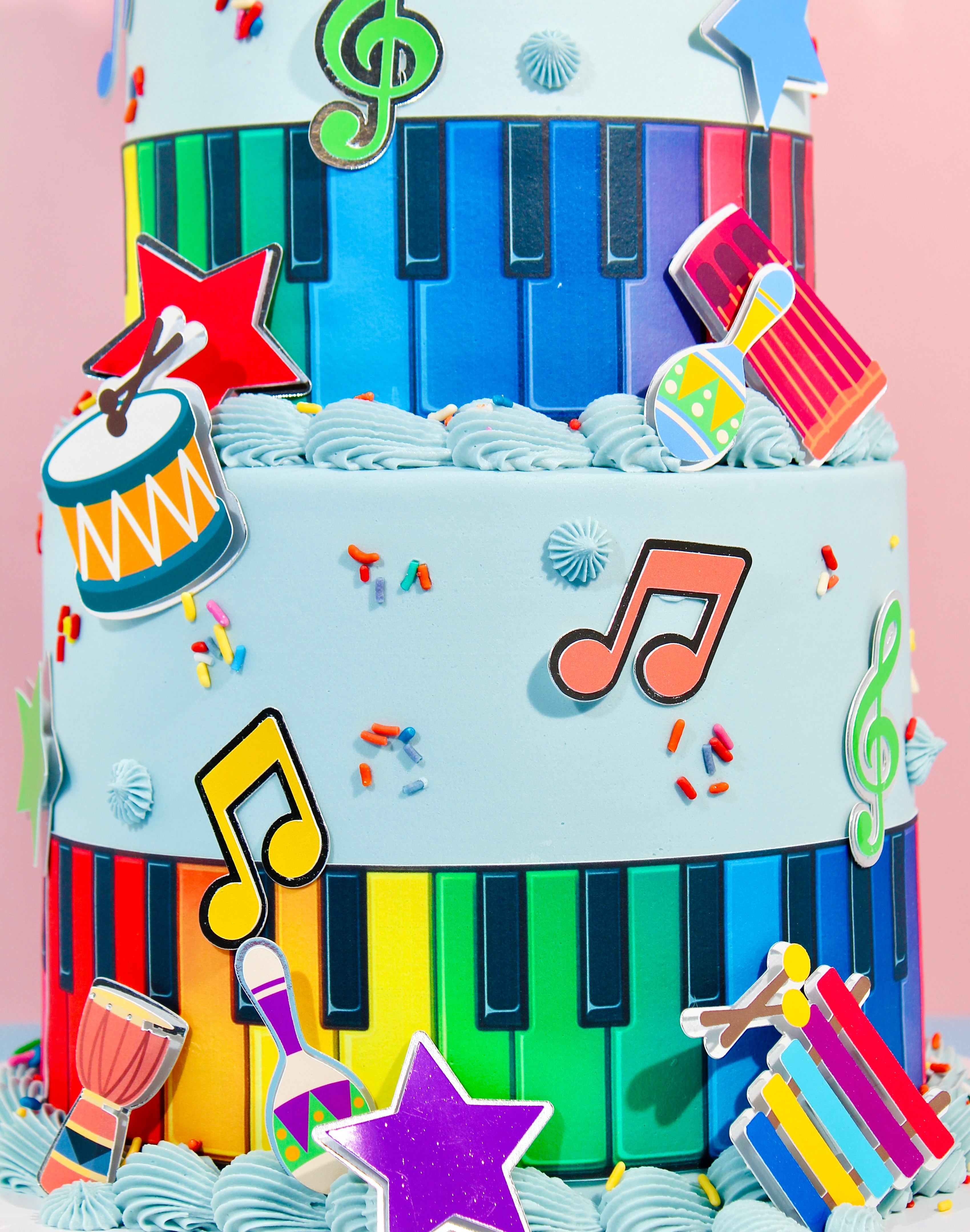Detailed view of rainbow piano key cake with musical instruments and notes