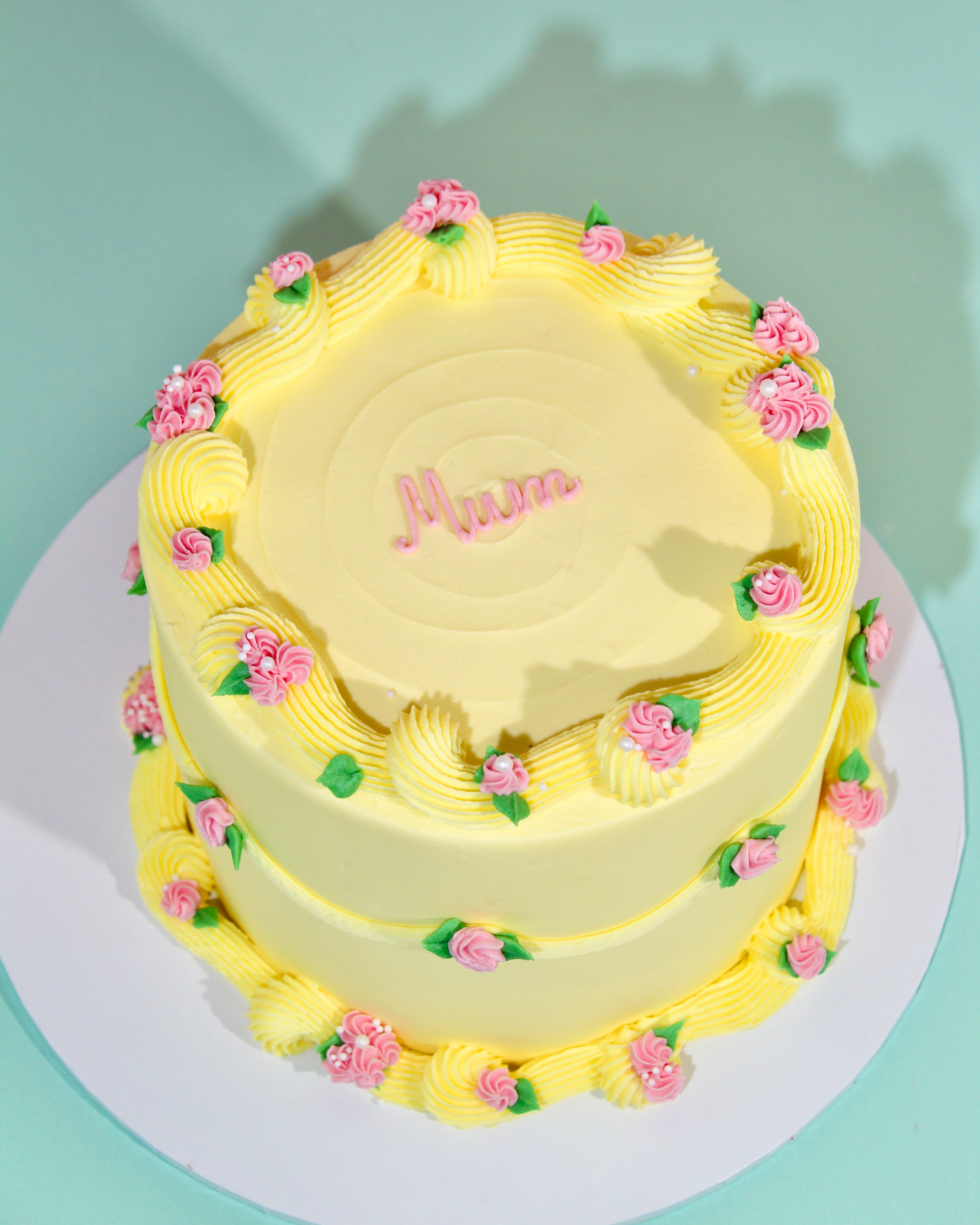 Buttercup bloom cake with yellow buttercream and pink roses