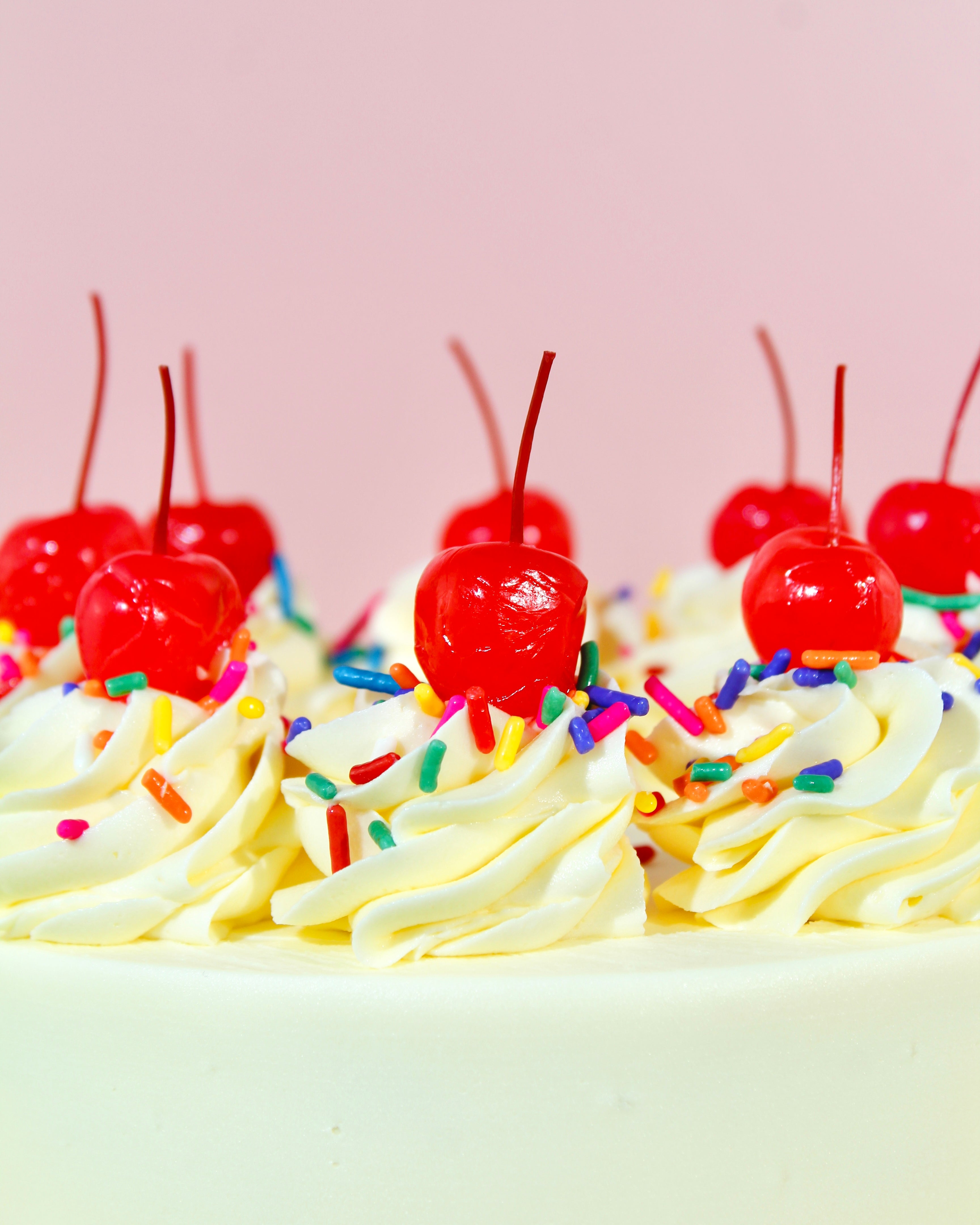 Vanilla buttercream cake with colourful sprinkles around the base