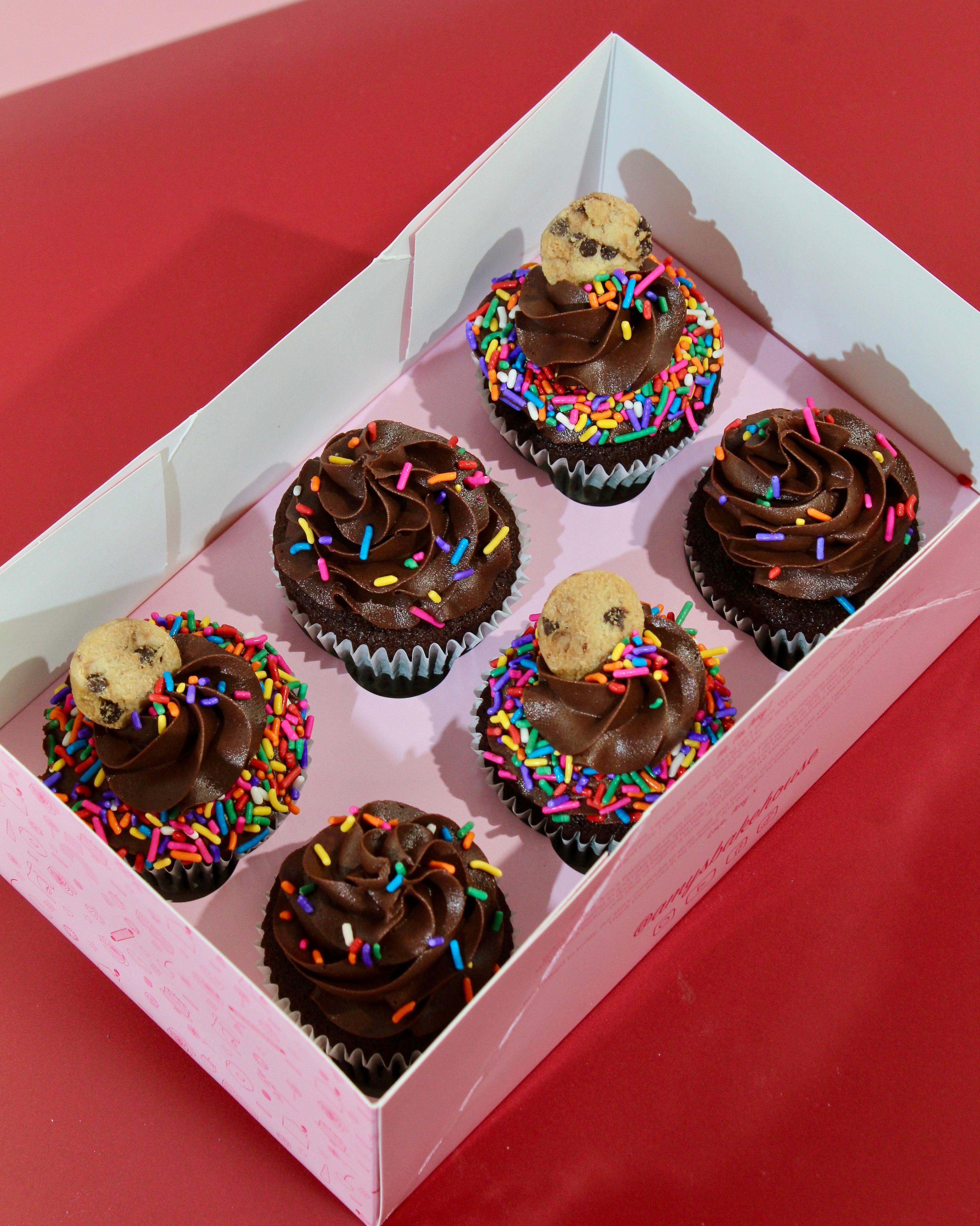 Chocolate cupcakes with rainbow sprinkles and cookie topping