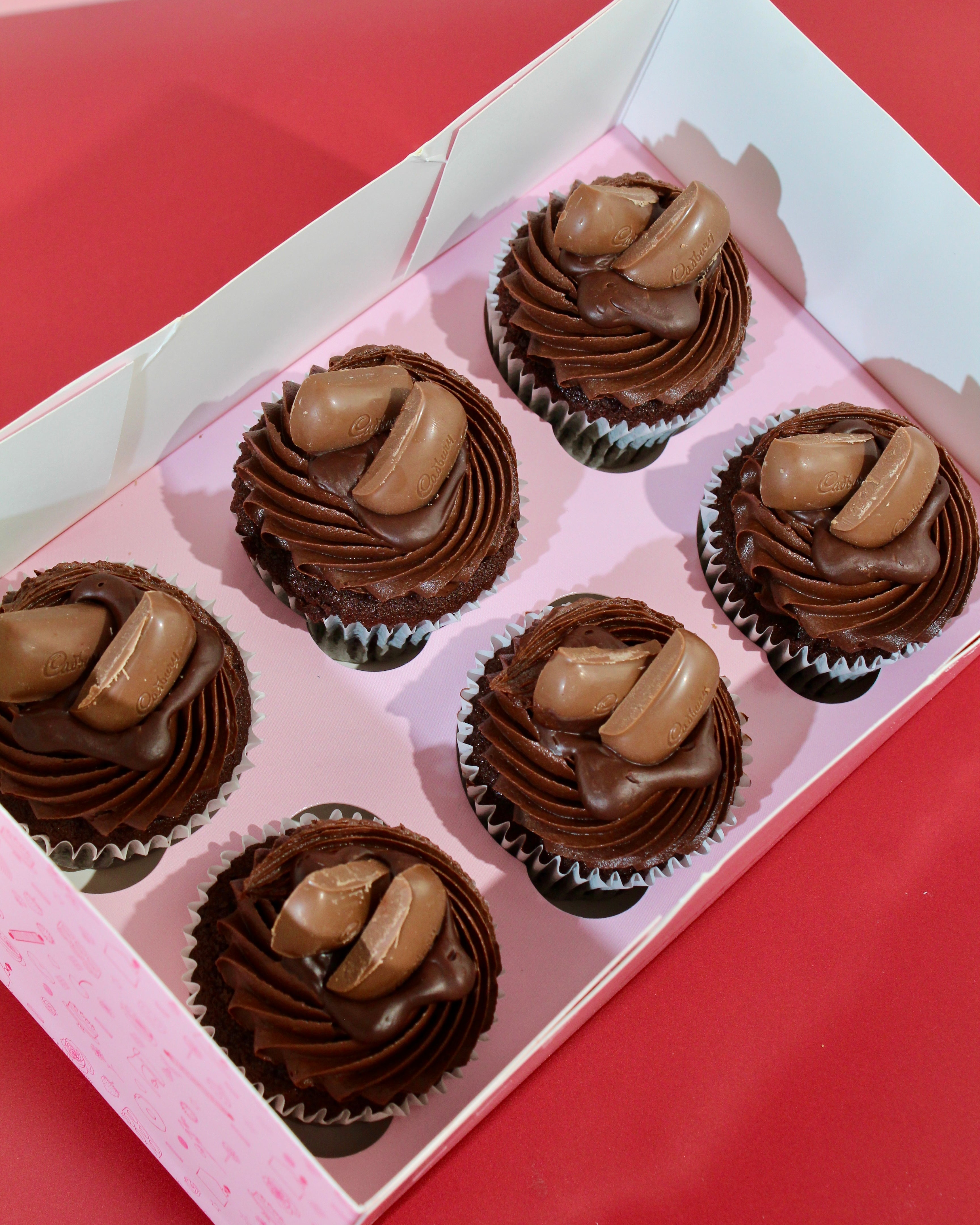 Six chocolate cupcakes with rich chocolate frosting and Cadbury chocolate topping