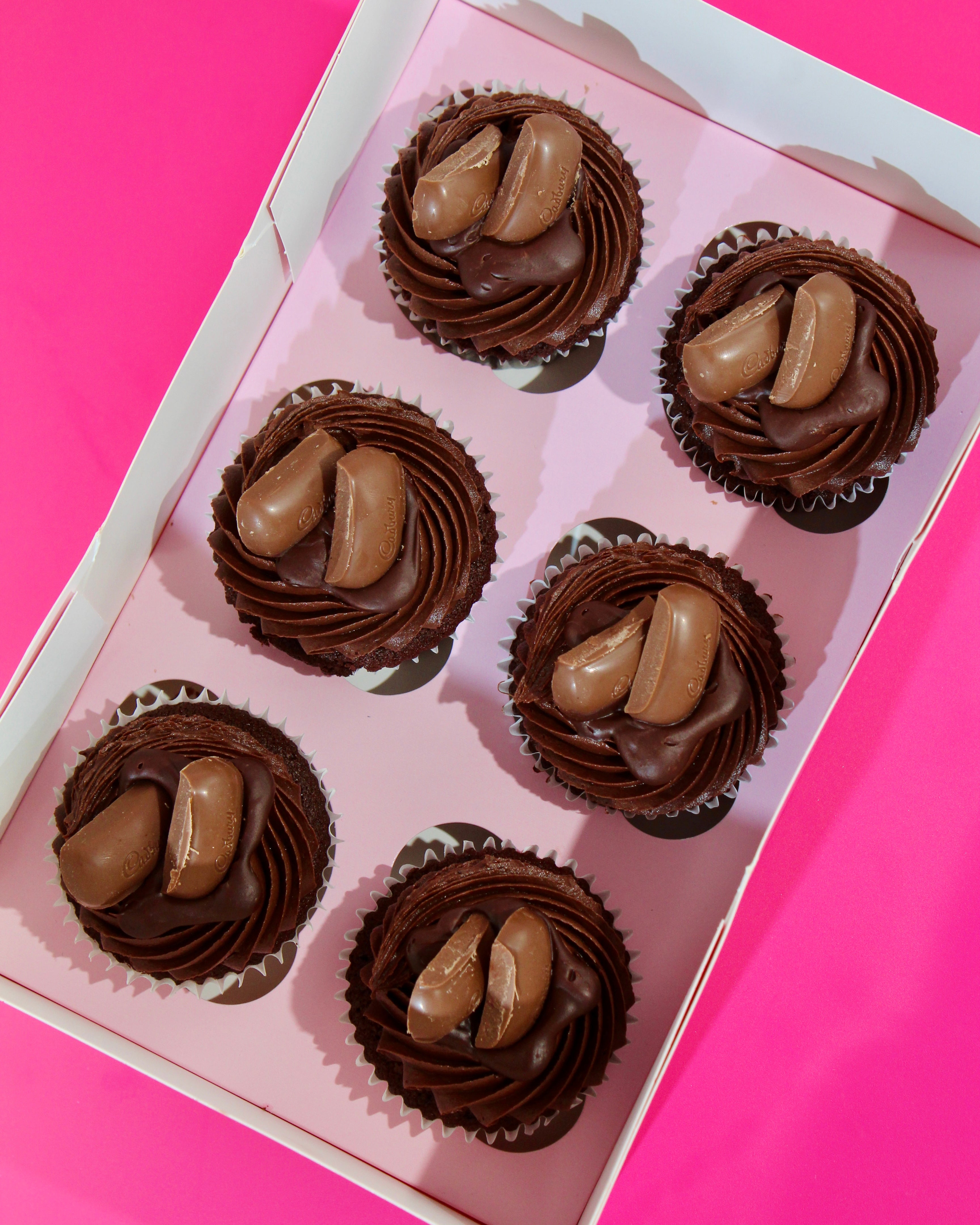 Top view of triple chocolate cupcakes in gift box with chocolate buttercream swirl