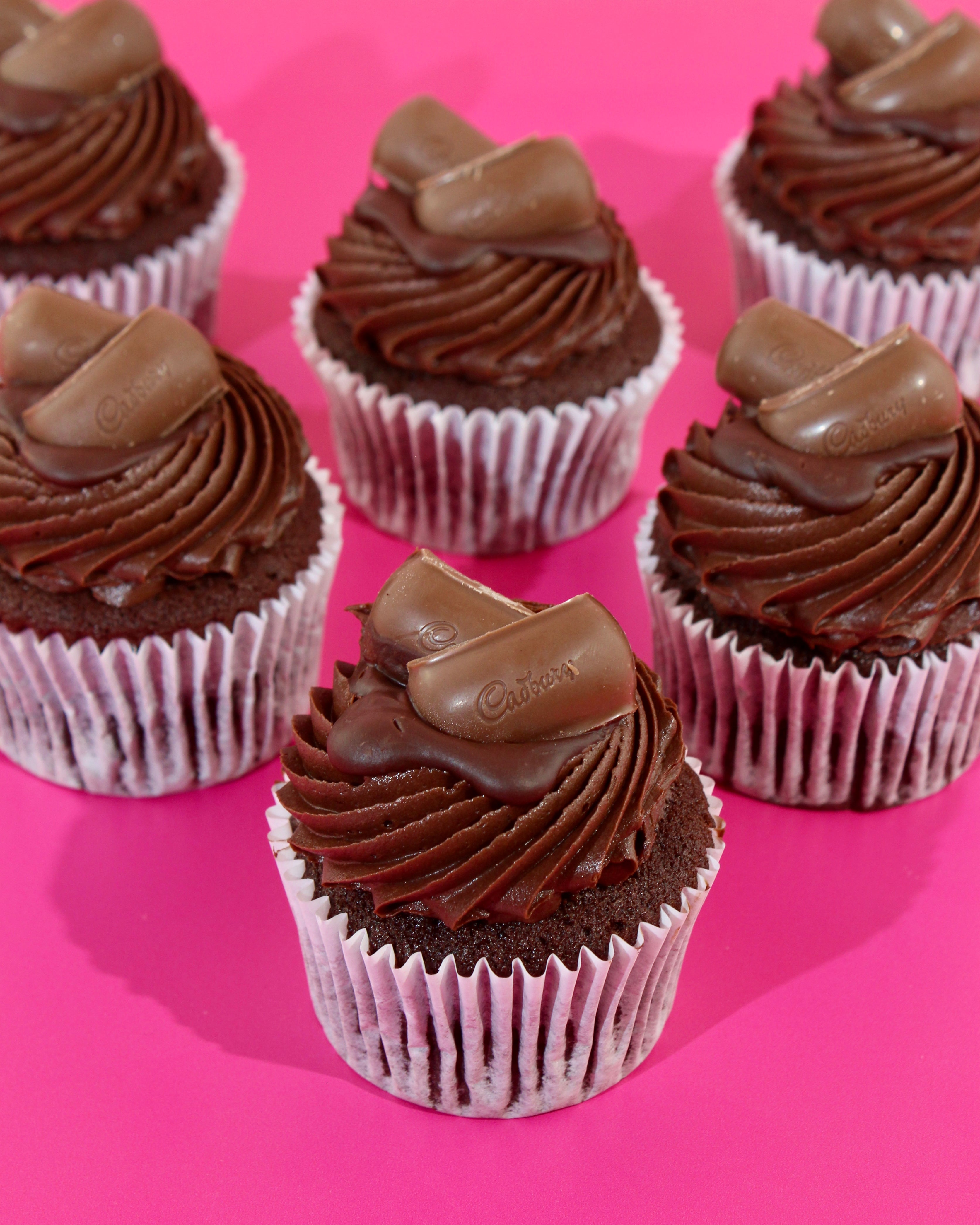 Close up of chocolate cupcake with chocolate buttercream and Cadbury topping