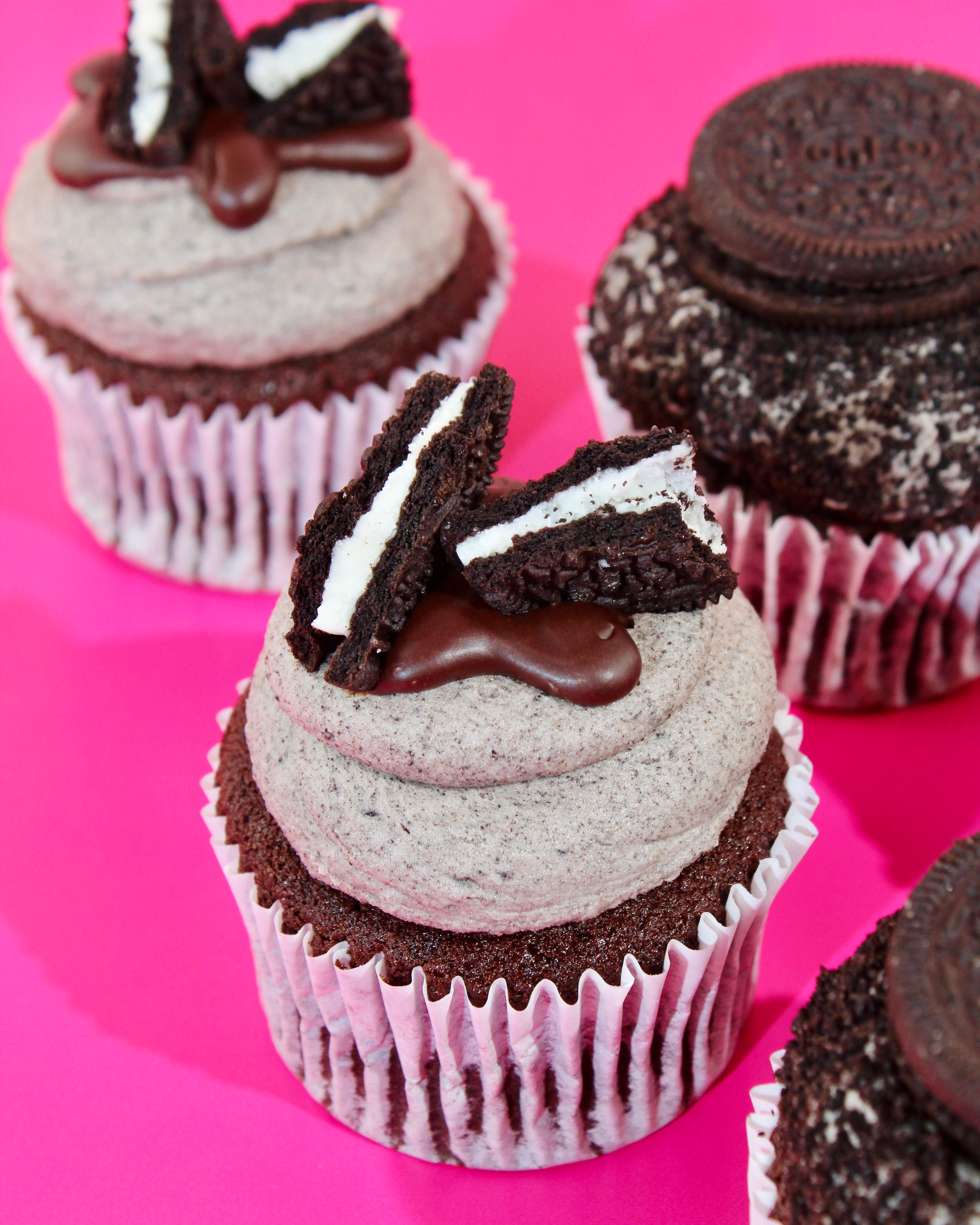 Cupcakes with Oreo cookie pieces on a pink background