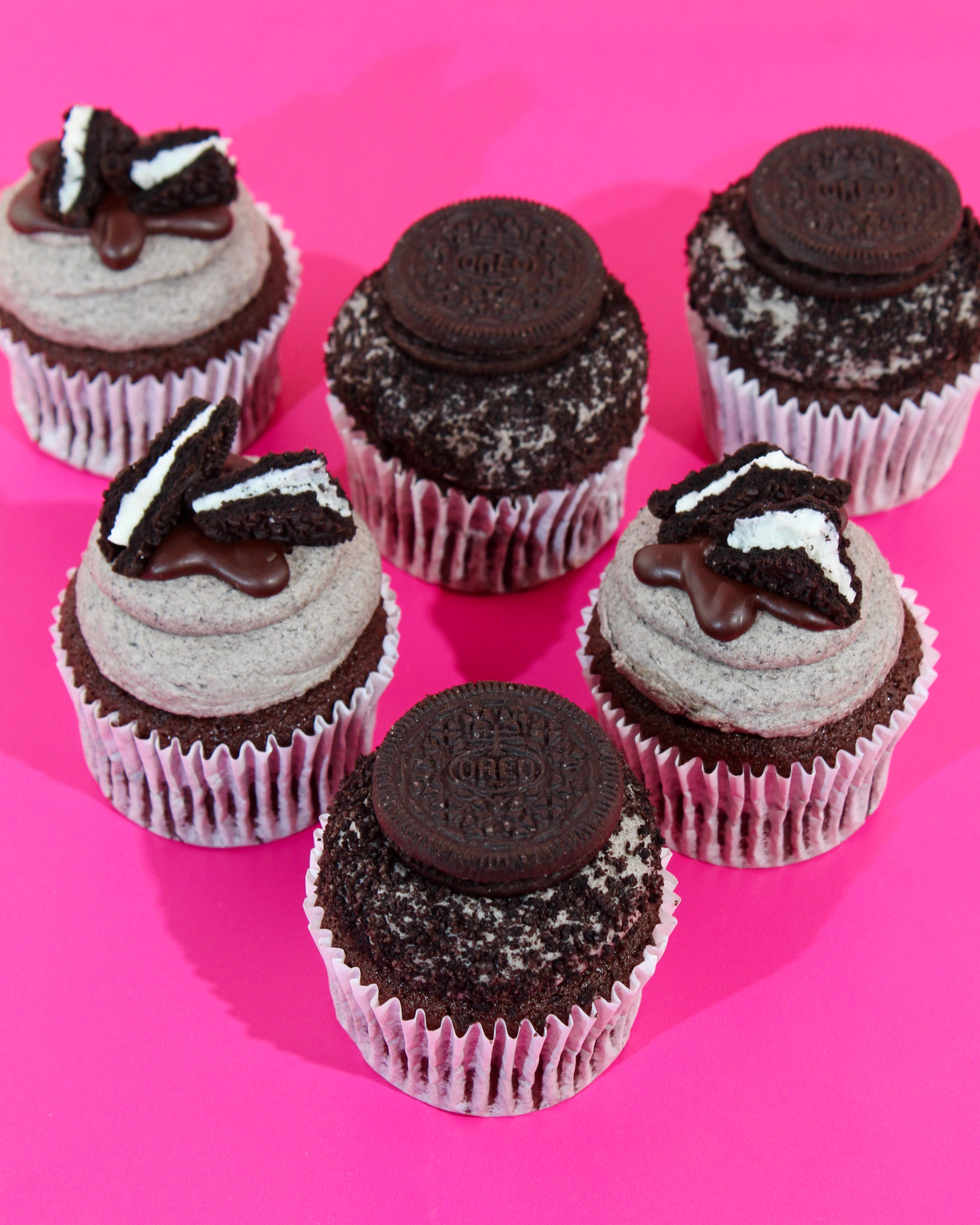 Cupcakes decorated with Oreo cookies on a pink background