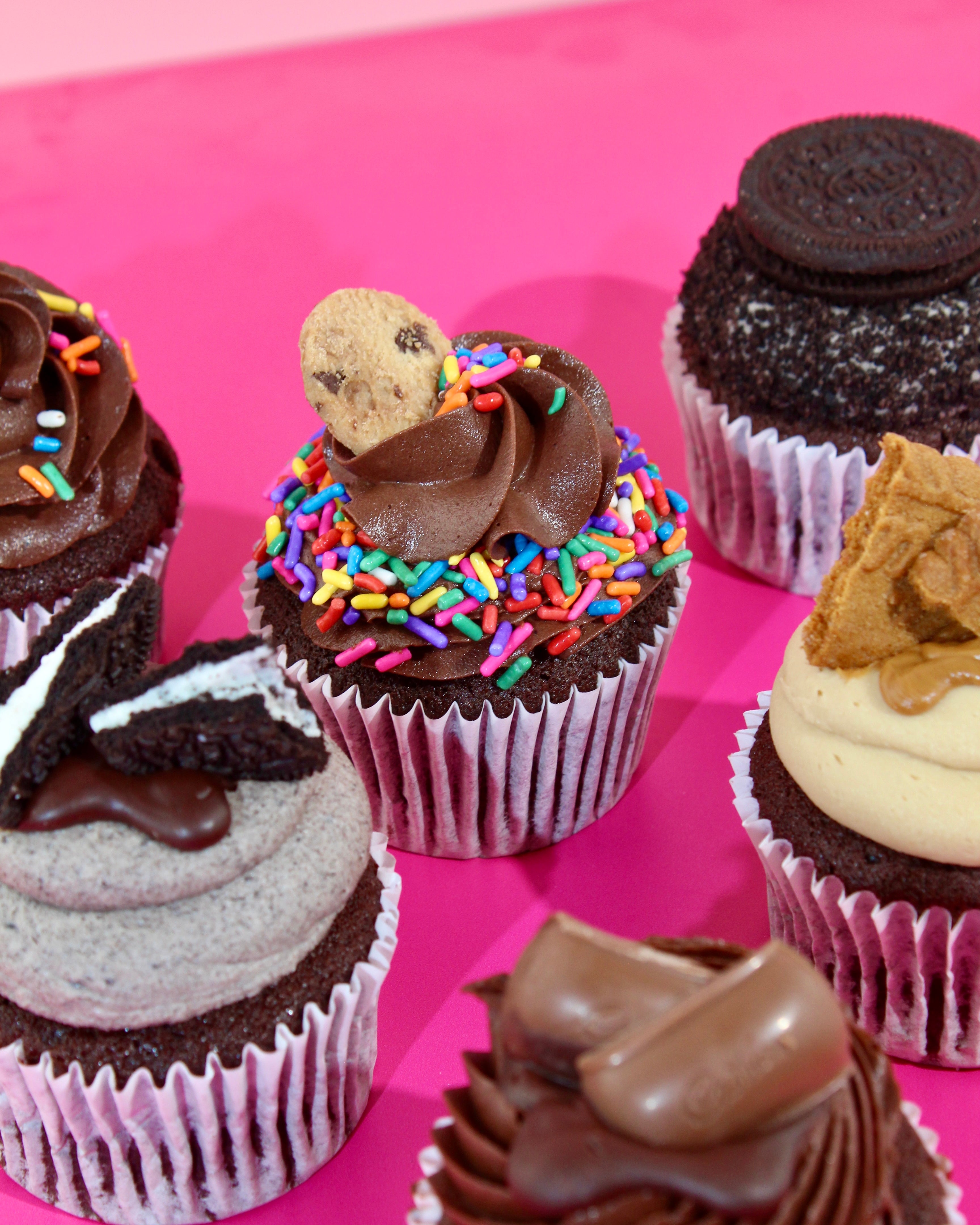 Selection of decorated cupcakes with buttercream and biscuit toppings