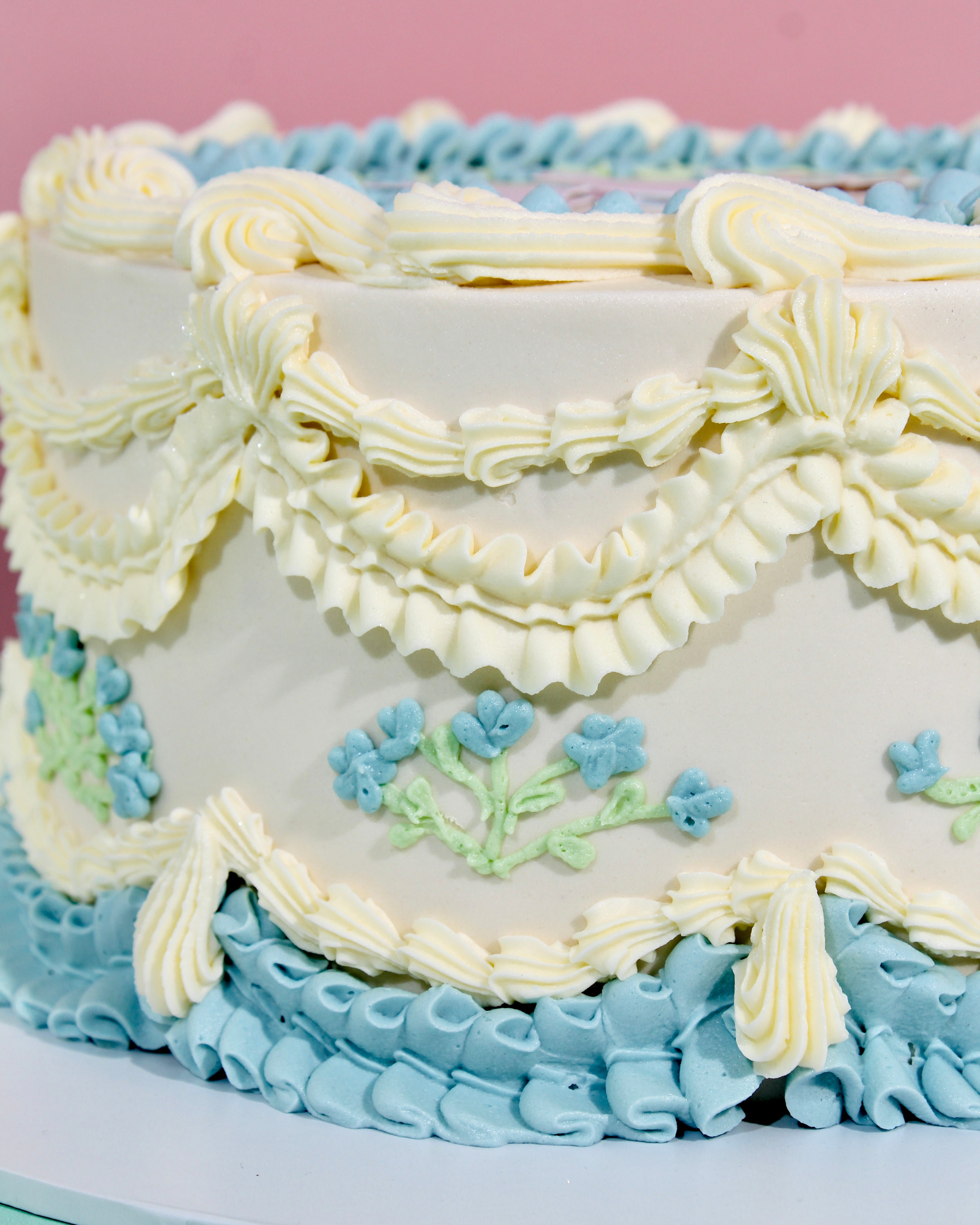 Delicate vintage piped buttercream rosettes and floral details in baby blue and cream