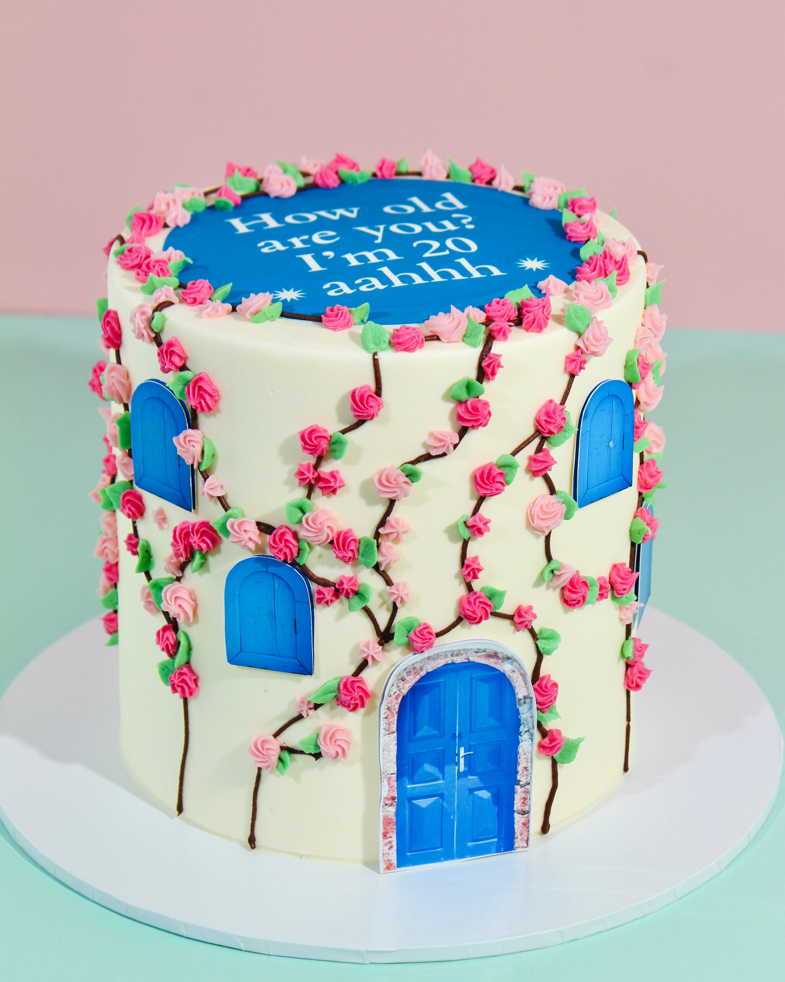 Decorative cake with cherry blossoms and blue doors on a light background