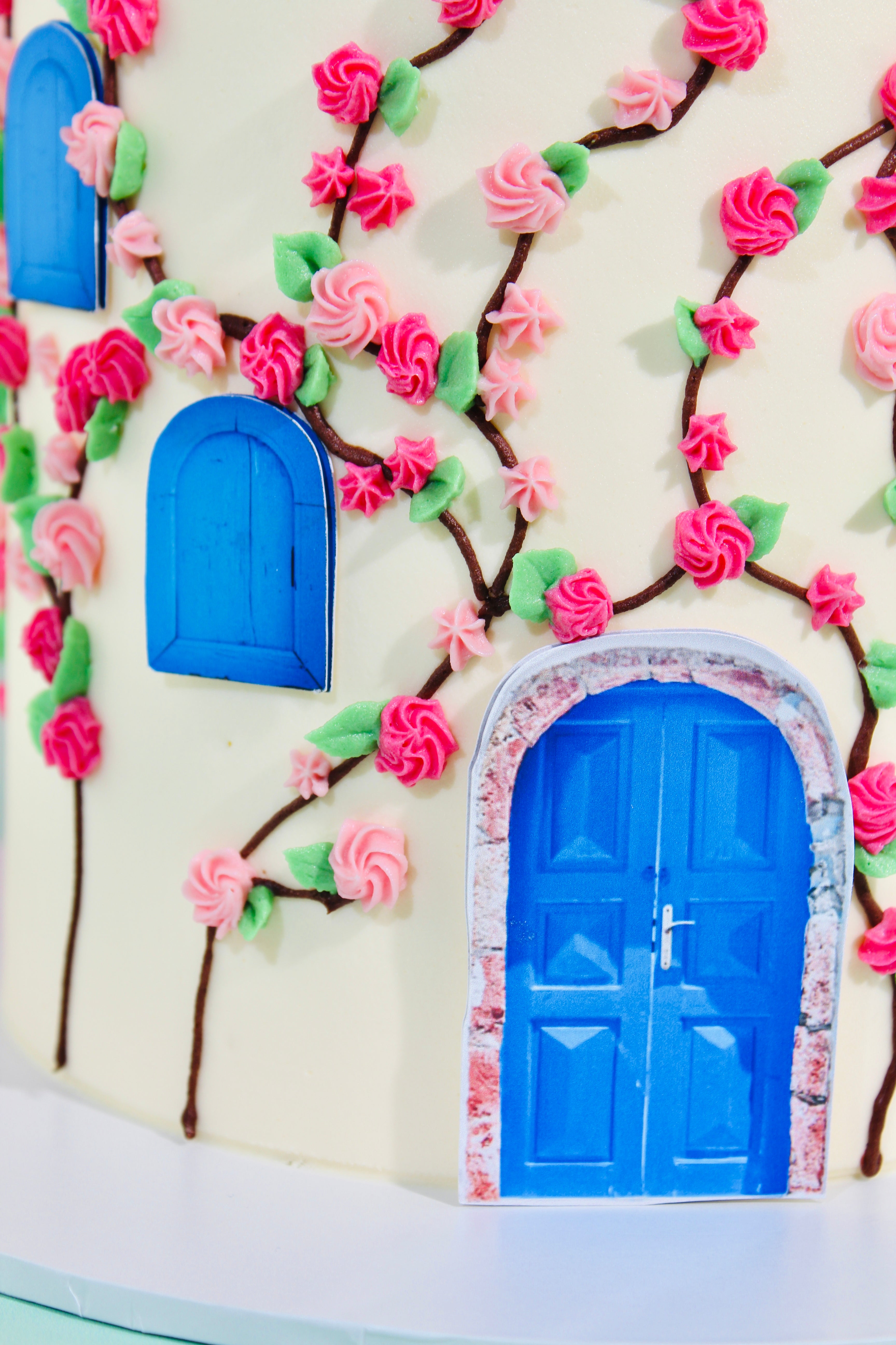 Decorative cake with blue doors and pink flowers