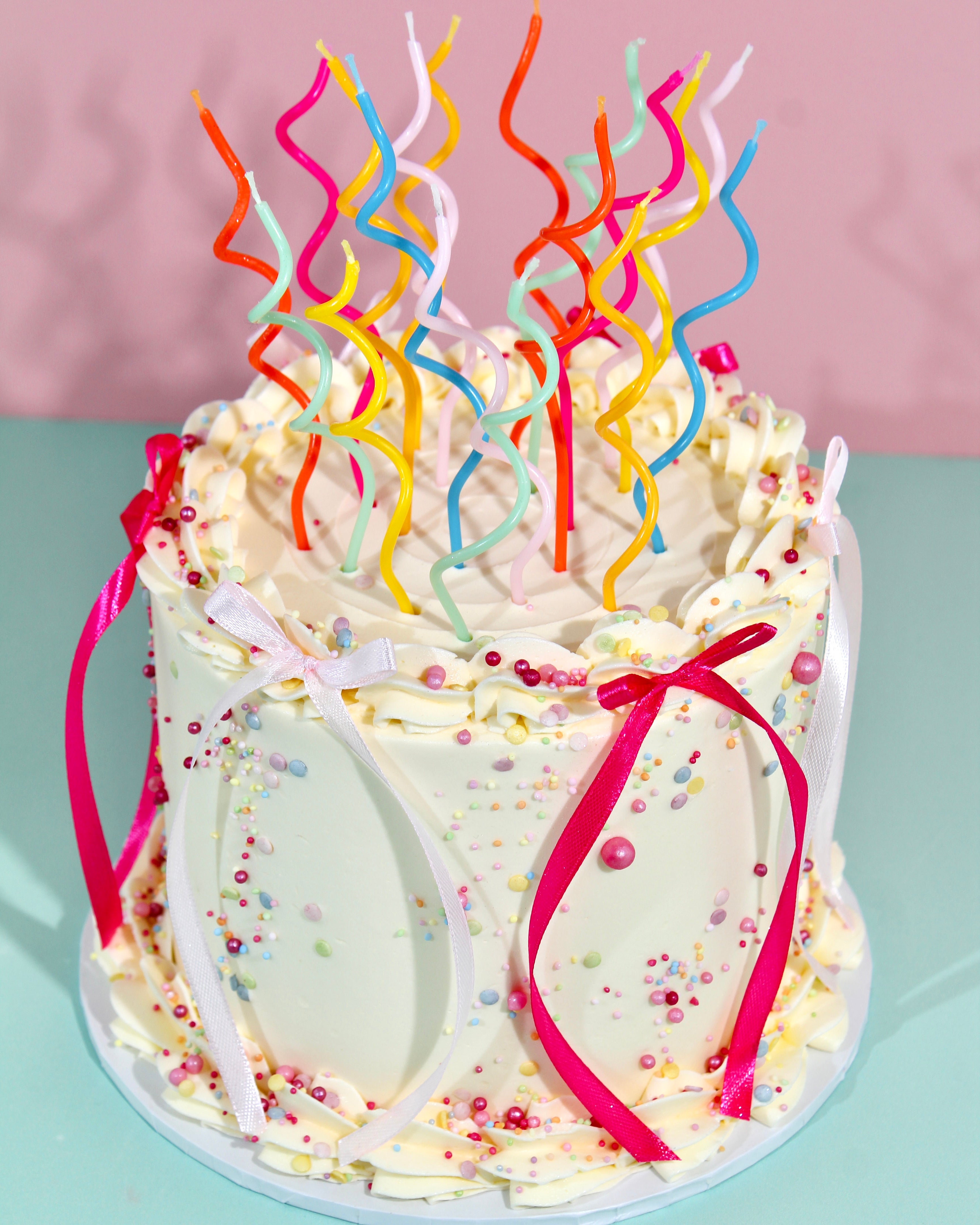 Fun sprinkle birthday cake with ribbons and personalised piped message on top