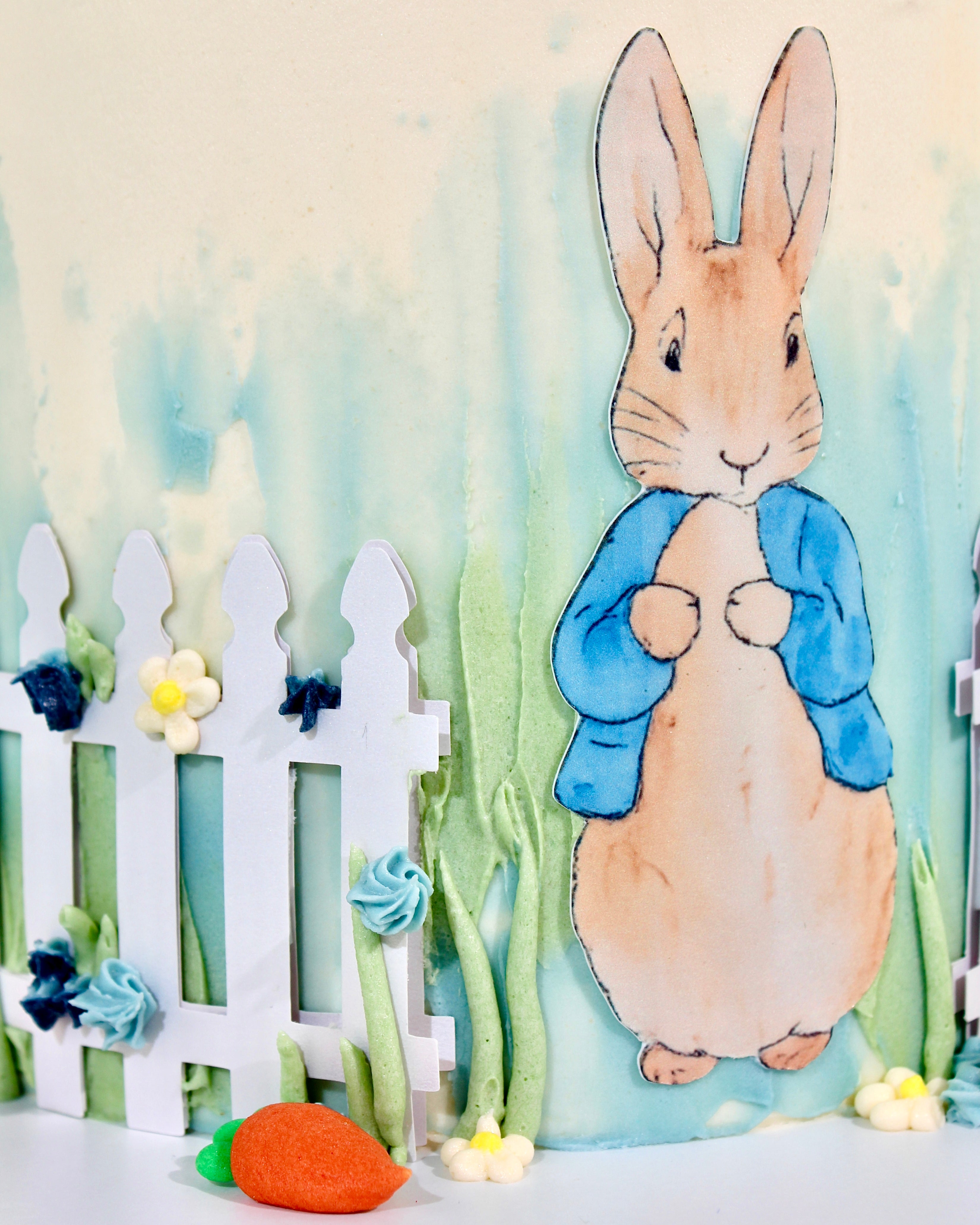 Peter Rabbit inspired first birthday cake with personalised iced message on cake board