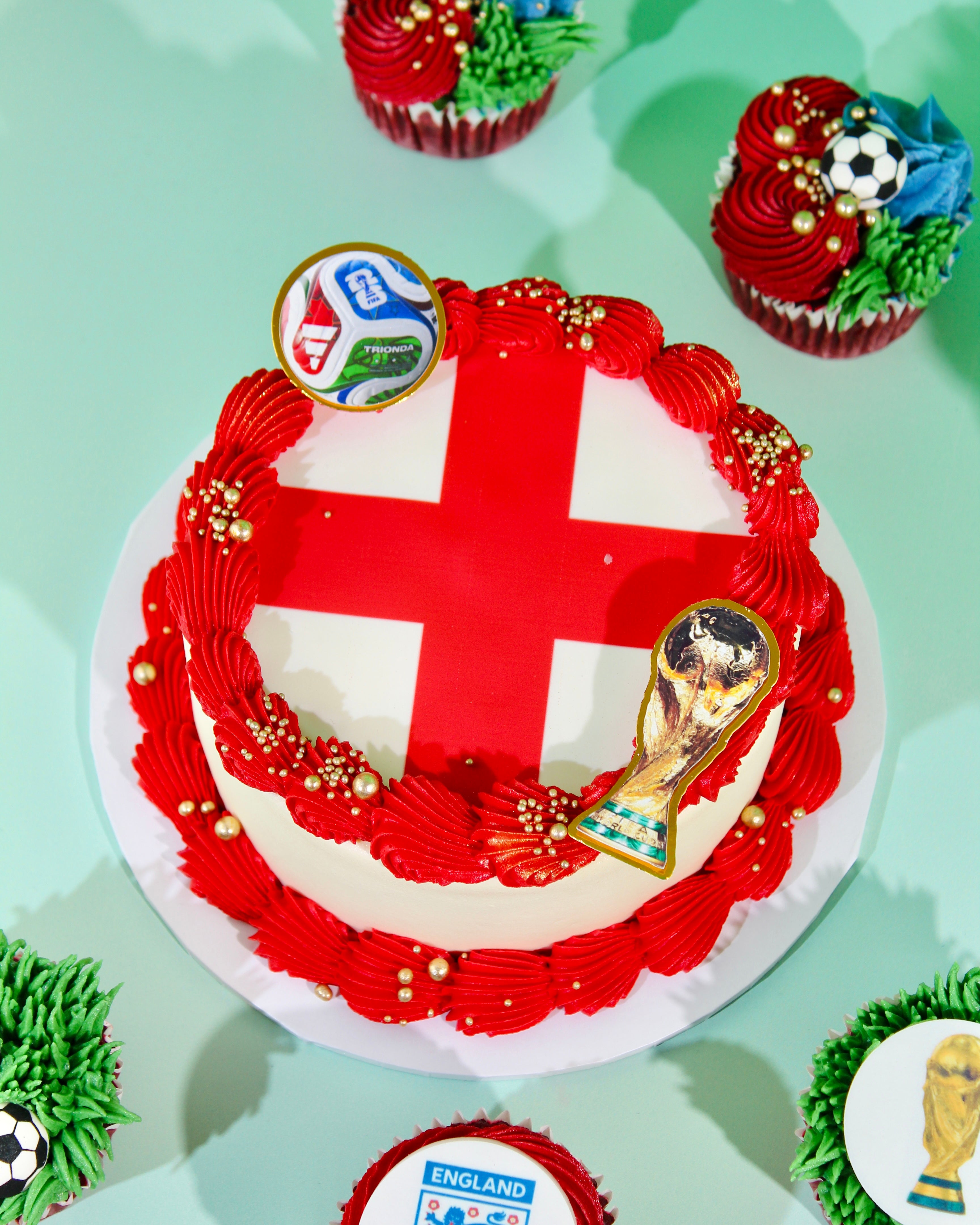 Bird's eye view of St George's Cross England cake with World Cup trophy and tournament ball disc