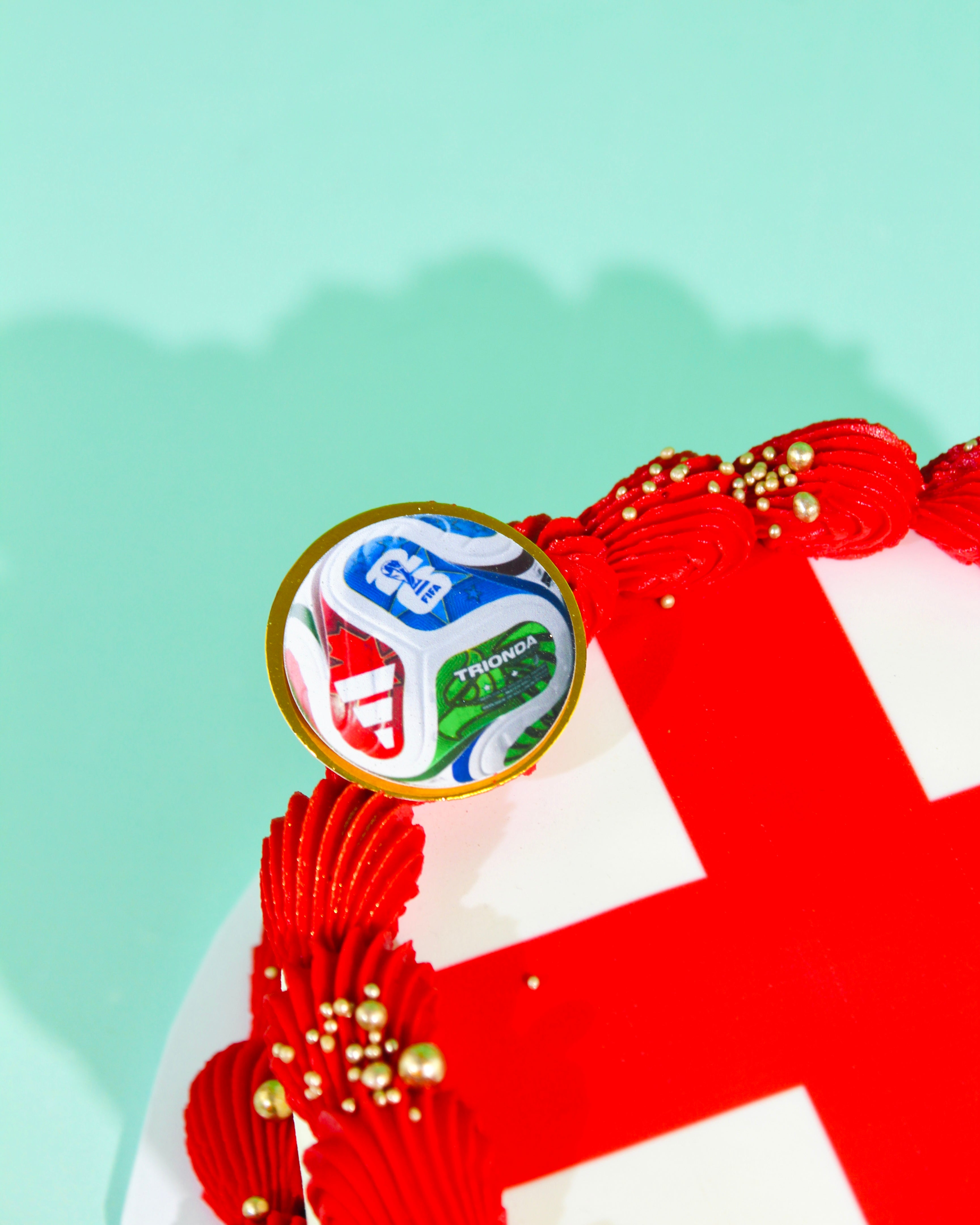 Close-up of World Cup 2026 tournament ball disc on red and white England buttercream cake