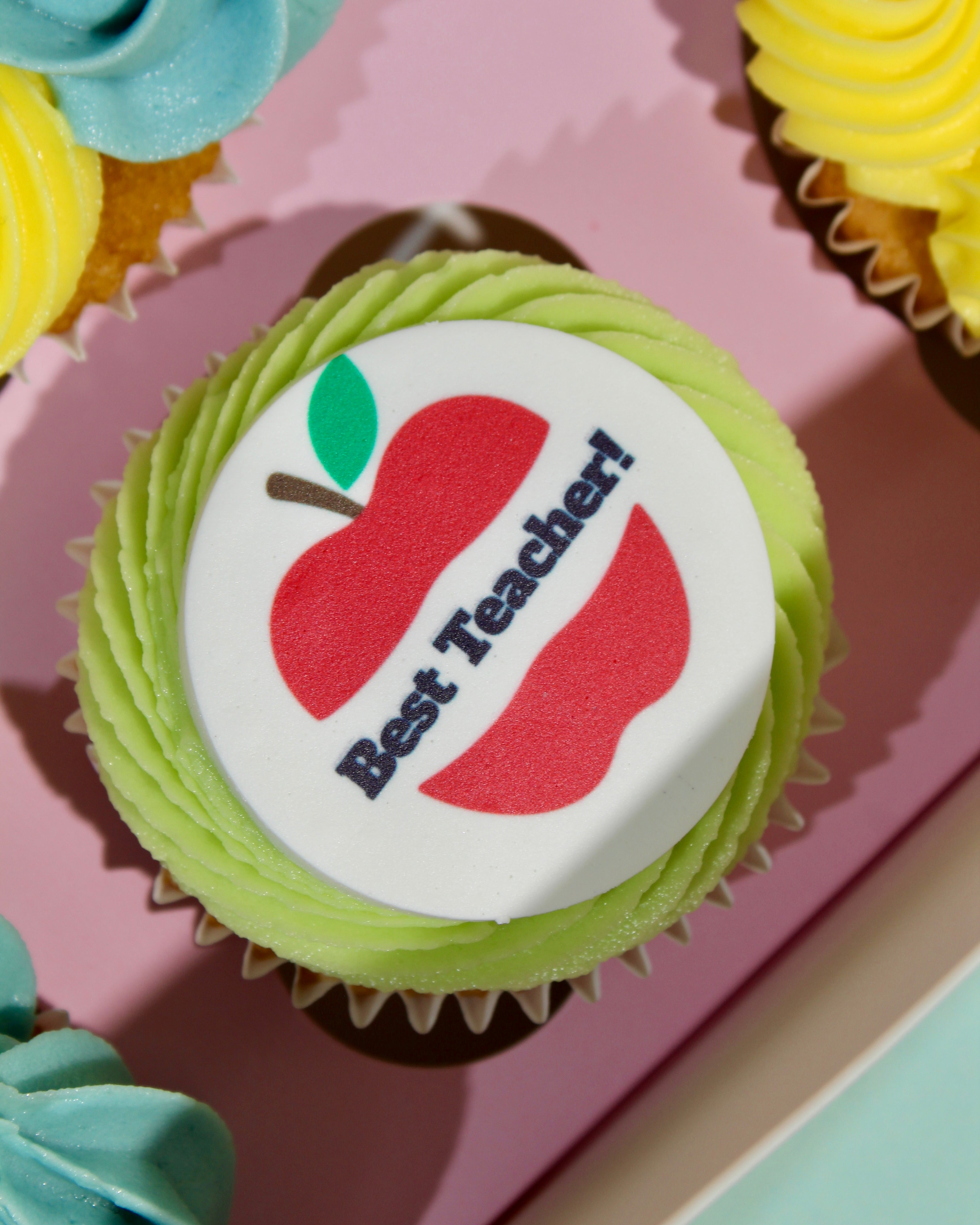 Close-up of Best Teacher cupcake with red apple disc and green lime buttercream rosette