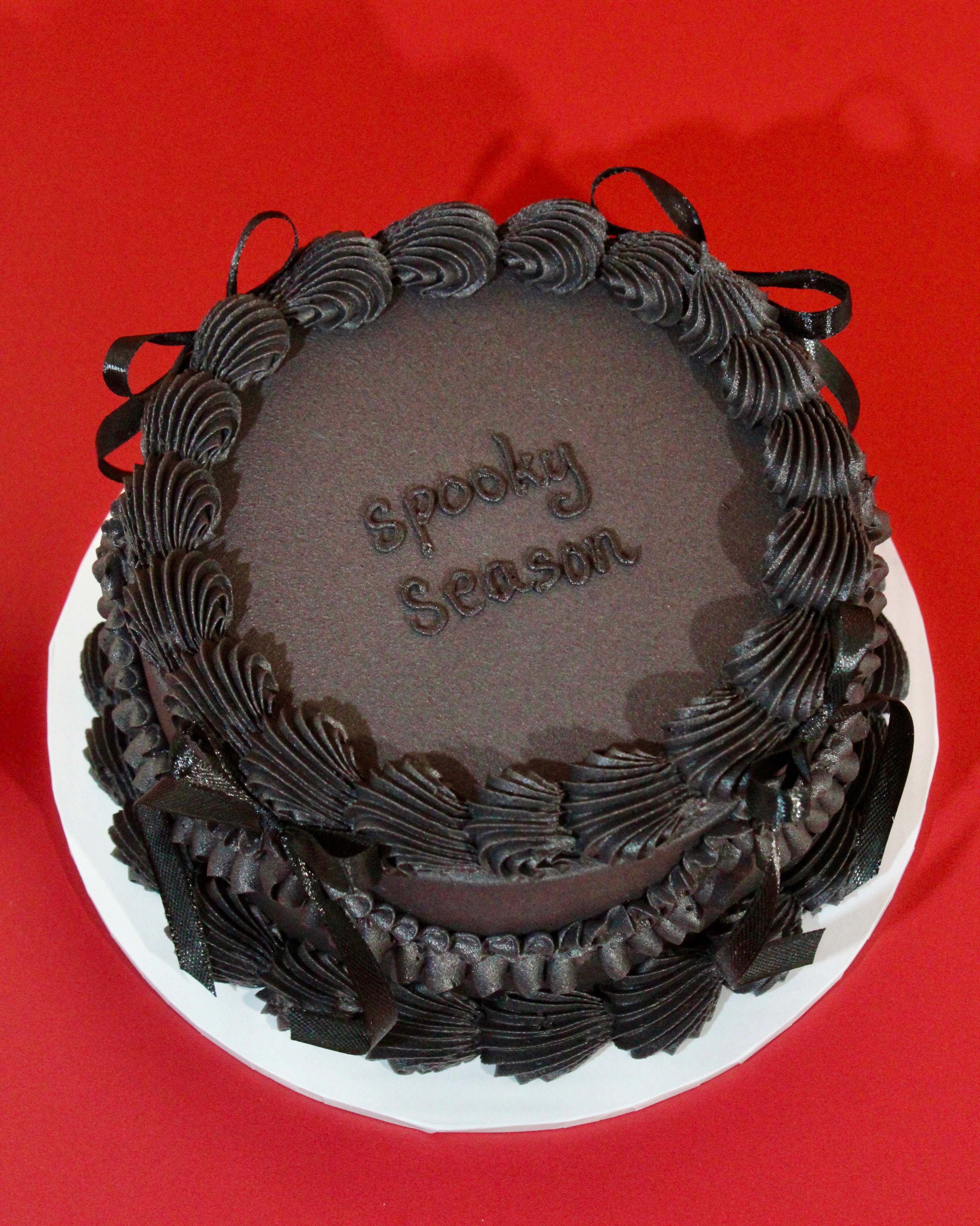 All-black Midnight Halloween cake with vintage piped buttercream borders, black ribbon bows and personalised iced message on top