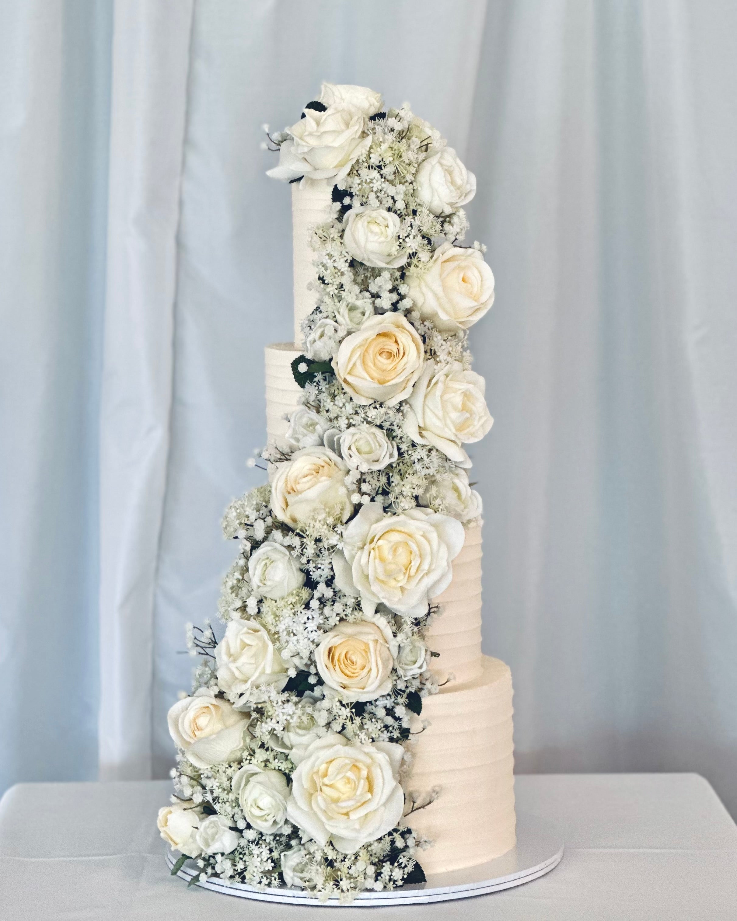 Elegant multi-tier wedding cake with cascading ivory floral design