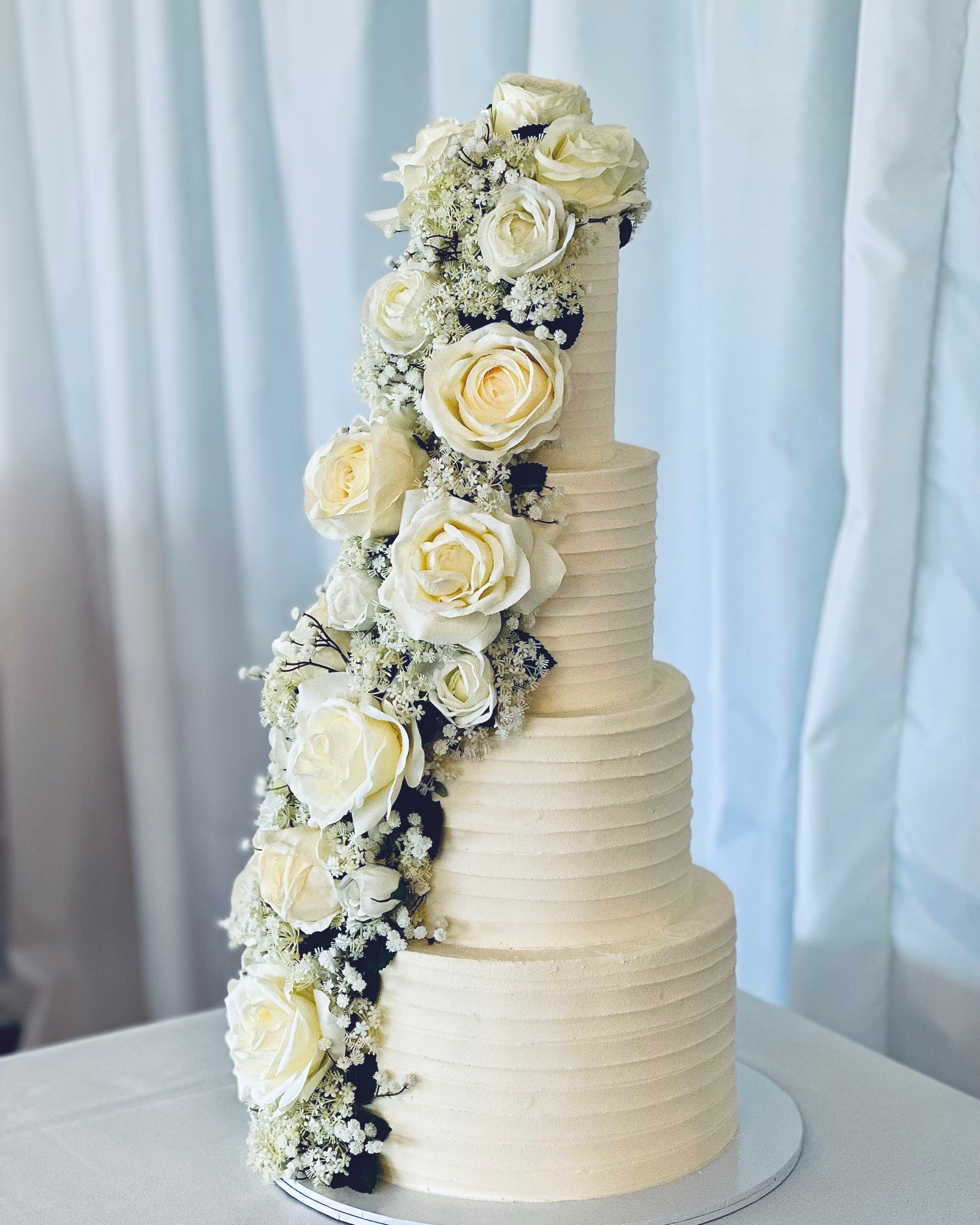Elegant multi-tier wedding cake with cascading ivory floral design