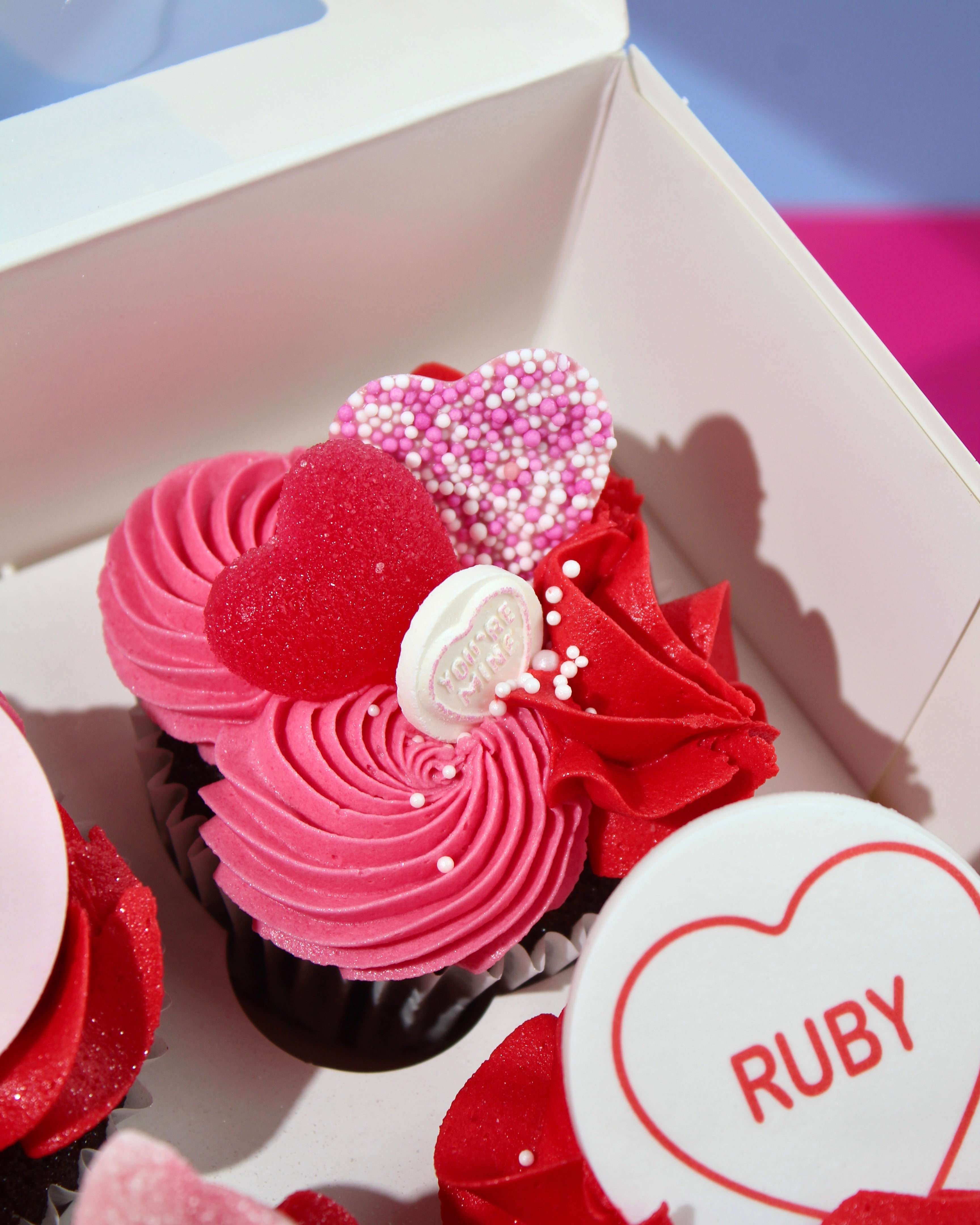 Galentine’s cupcakes with Valentine messages and heart toppers