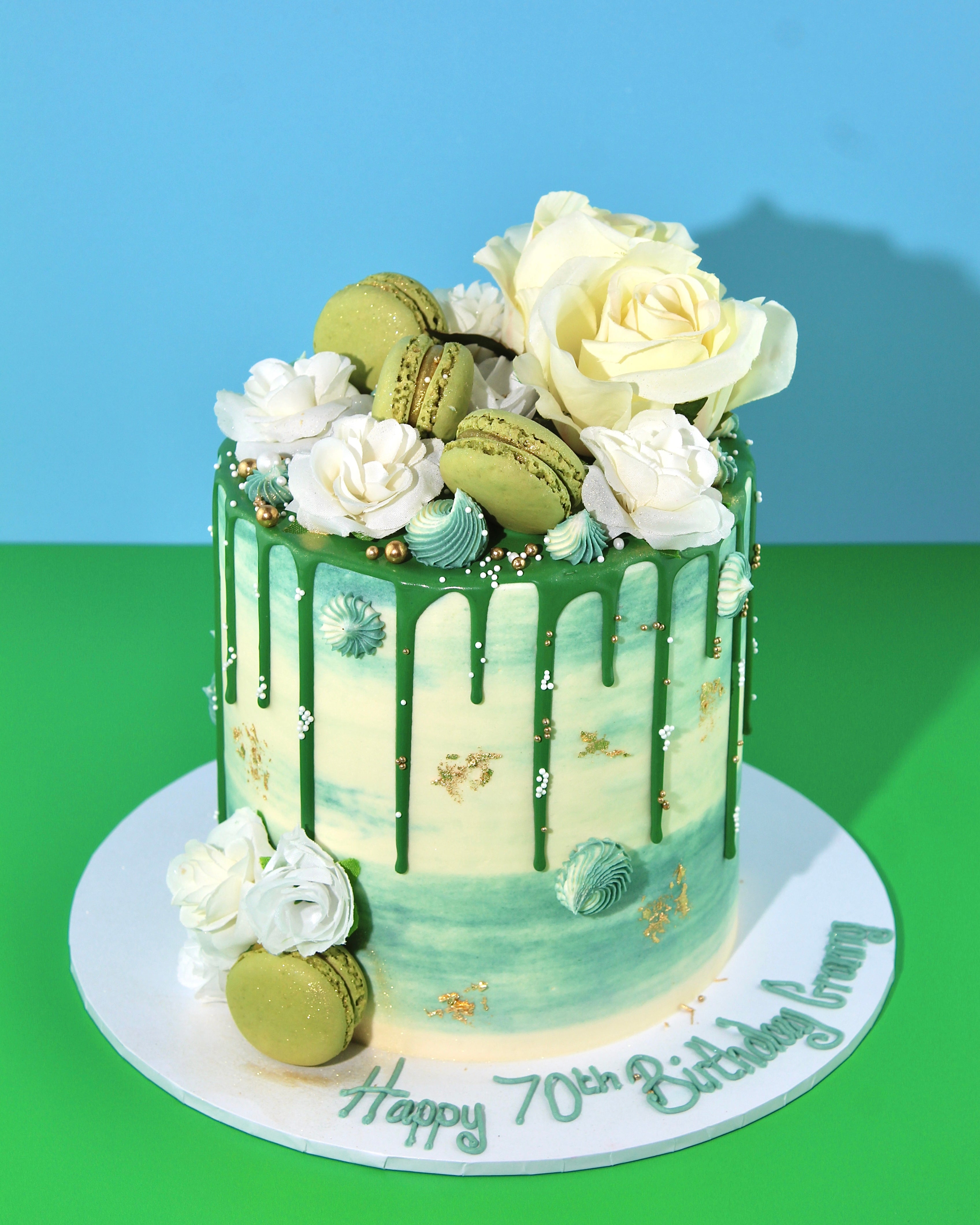 Tall green watercolour buttercream cake with personalised iced message on cake board