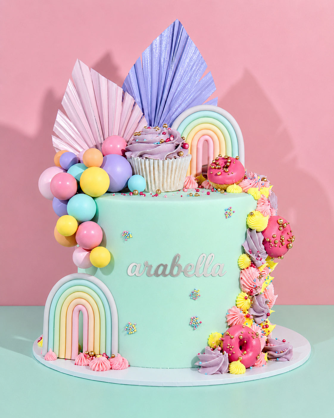 Colorful birthday cake with decorative elements on a pink background