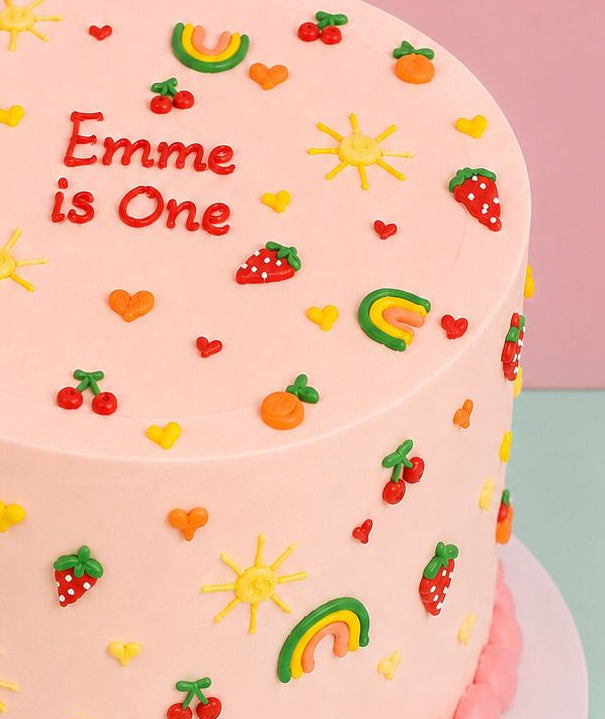 Cute summer doodle first birthday cake with cherries, strawberries and sunshine piped decorations