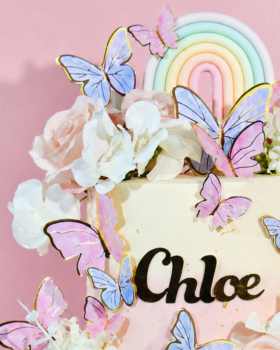 Decorative cake with butterflies and flowers on a pink background